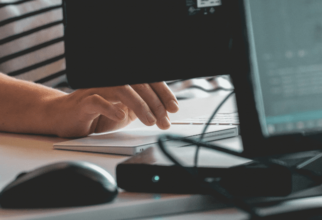 A hand typing at a keyboard