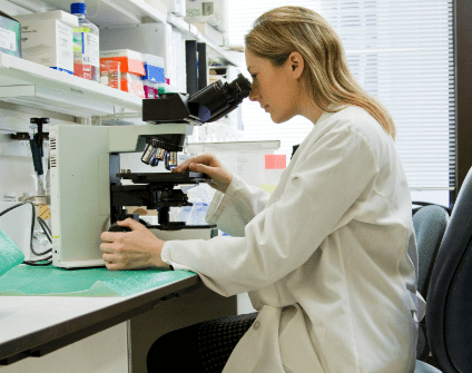 A scientist looking into a microscope