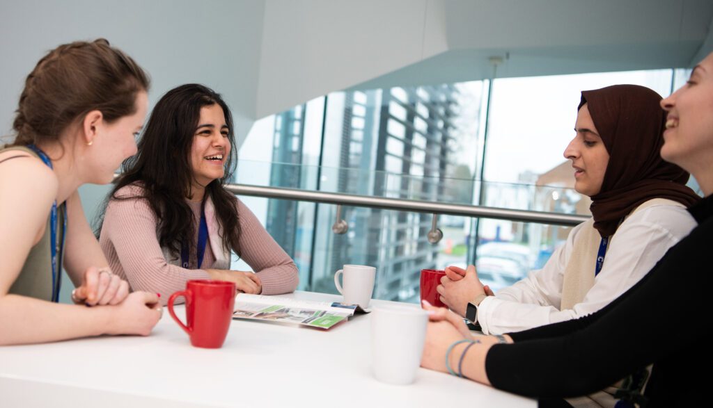 A group of researchers in discussion over coffee
