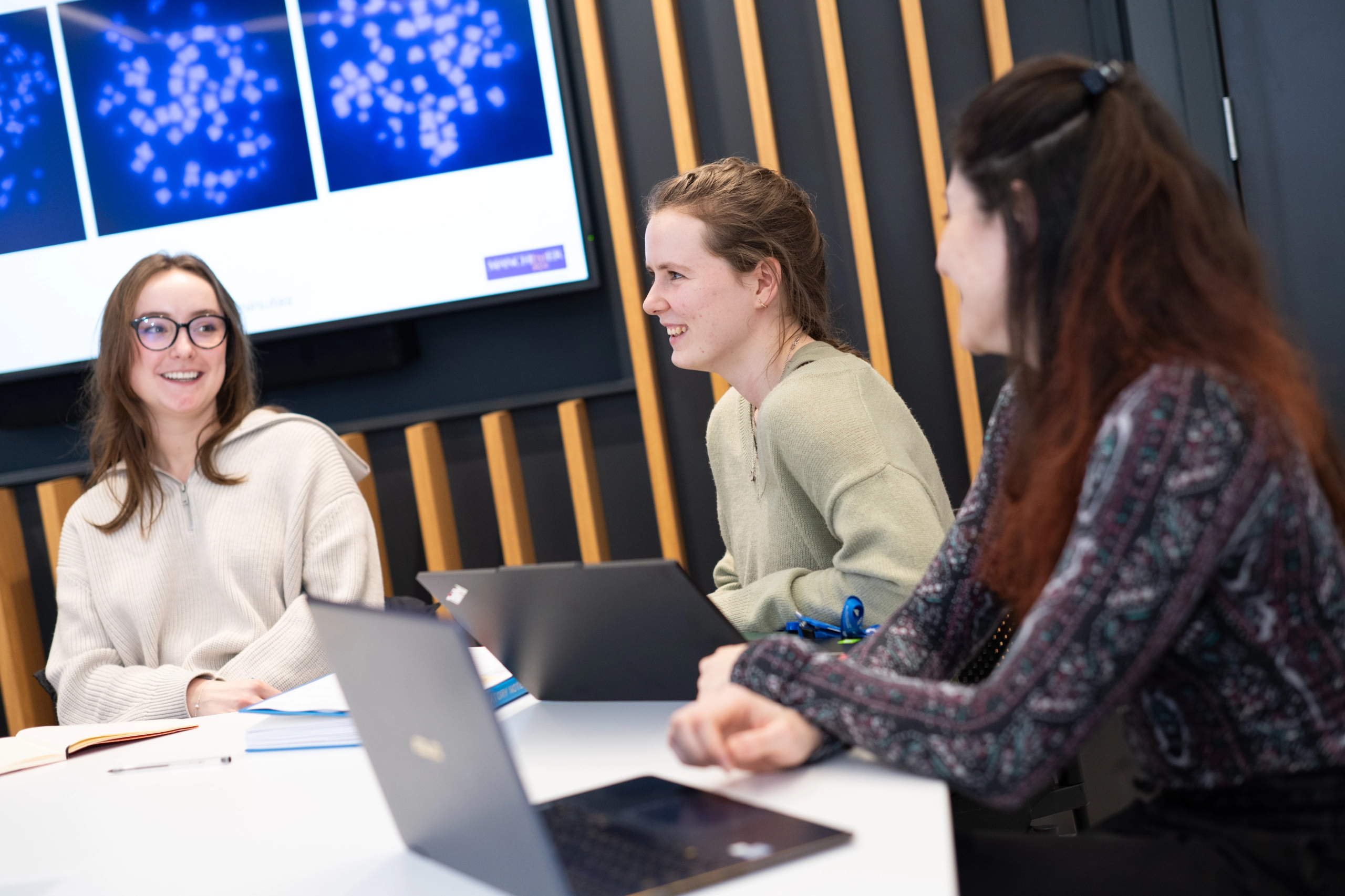 Laboratory researchers sat around a meeting table discussing results