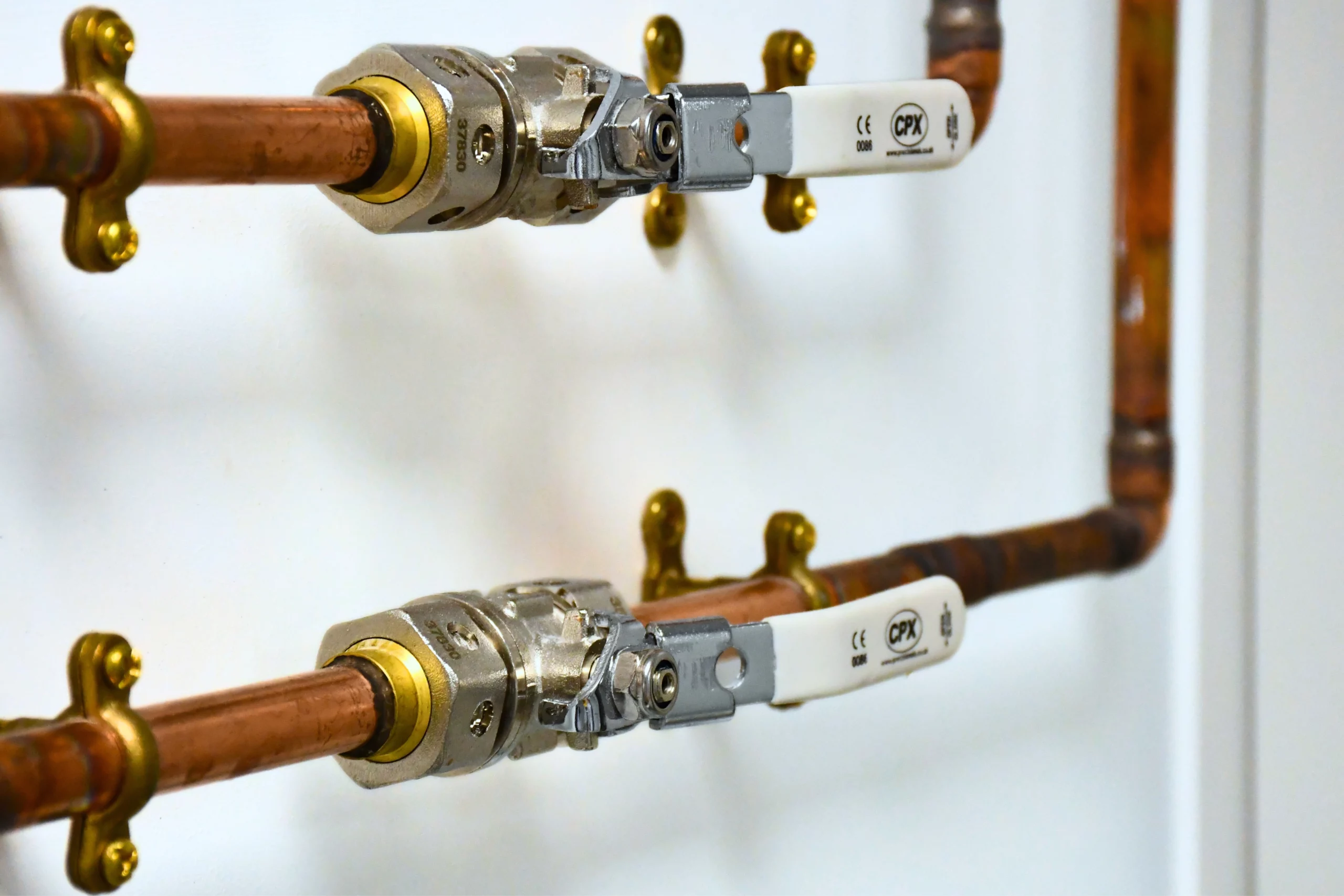 Two pipes carrying lab gasses on a white wall