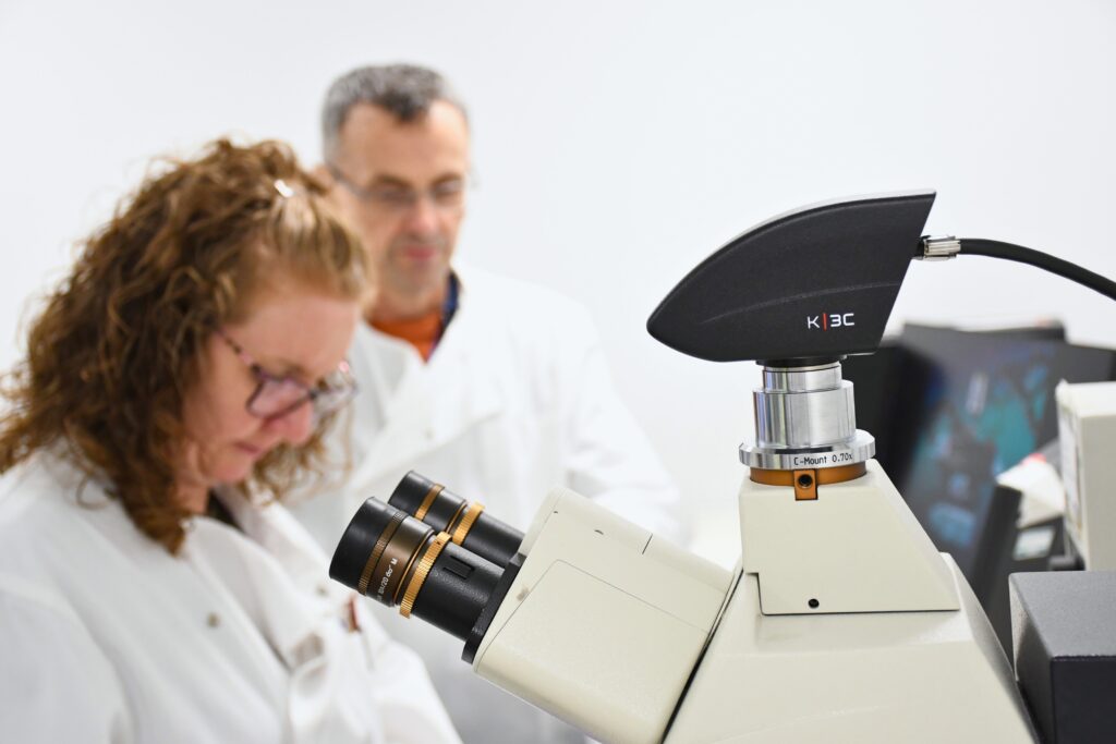 Microscope with team in background