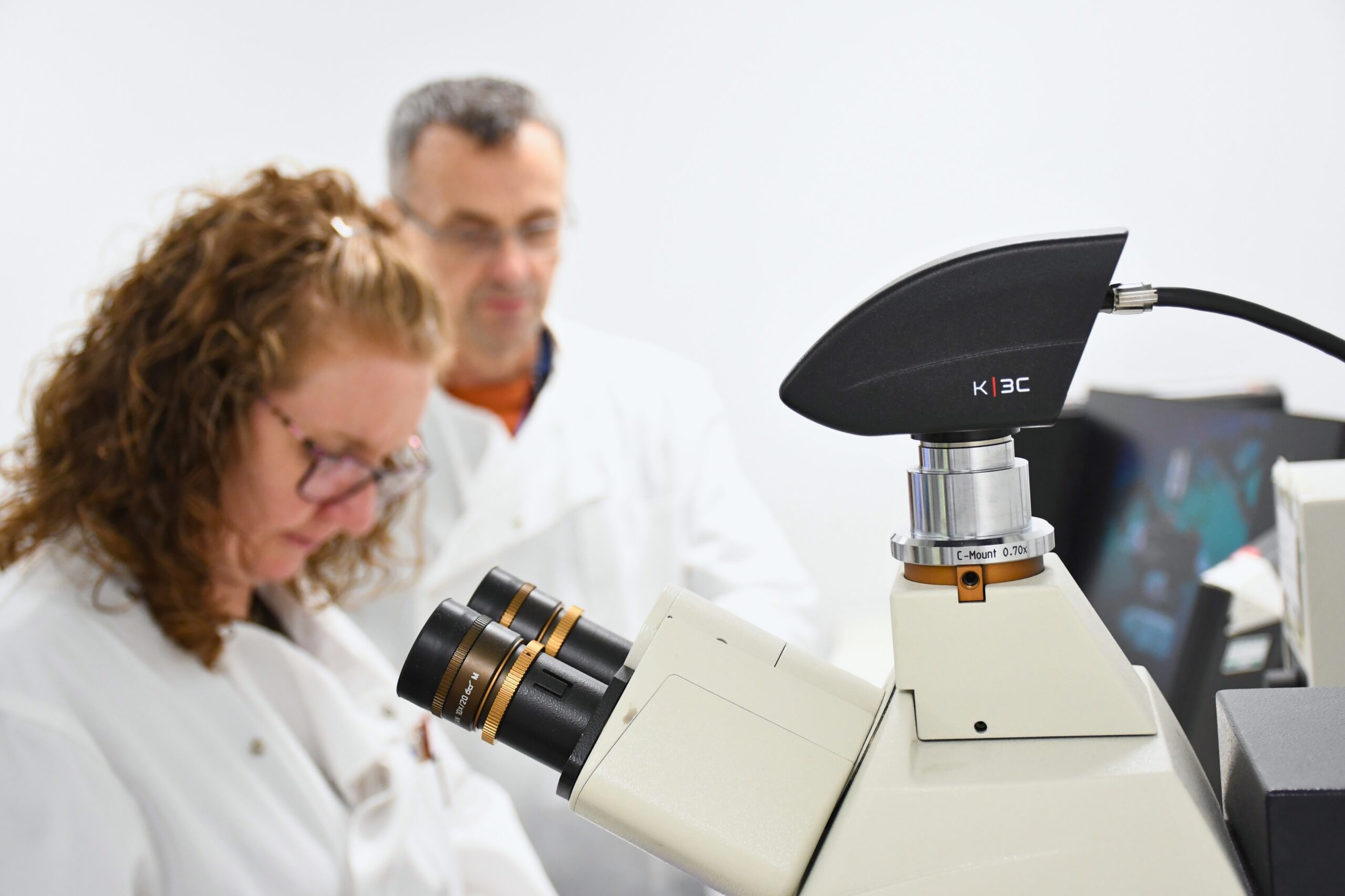 Microscope with team in background
